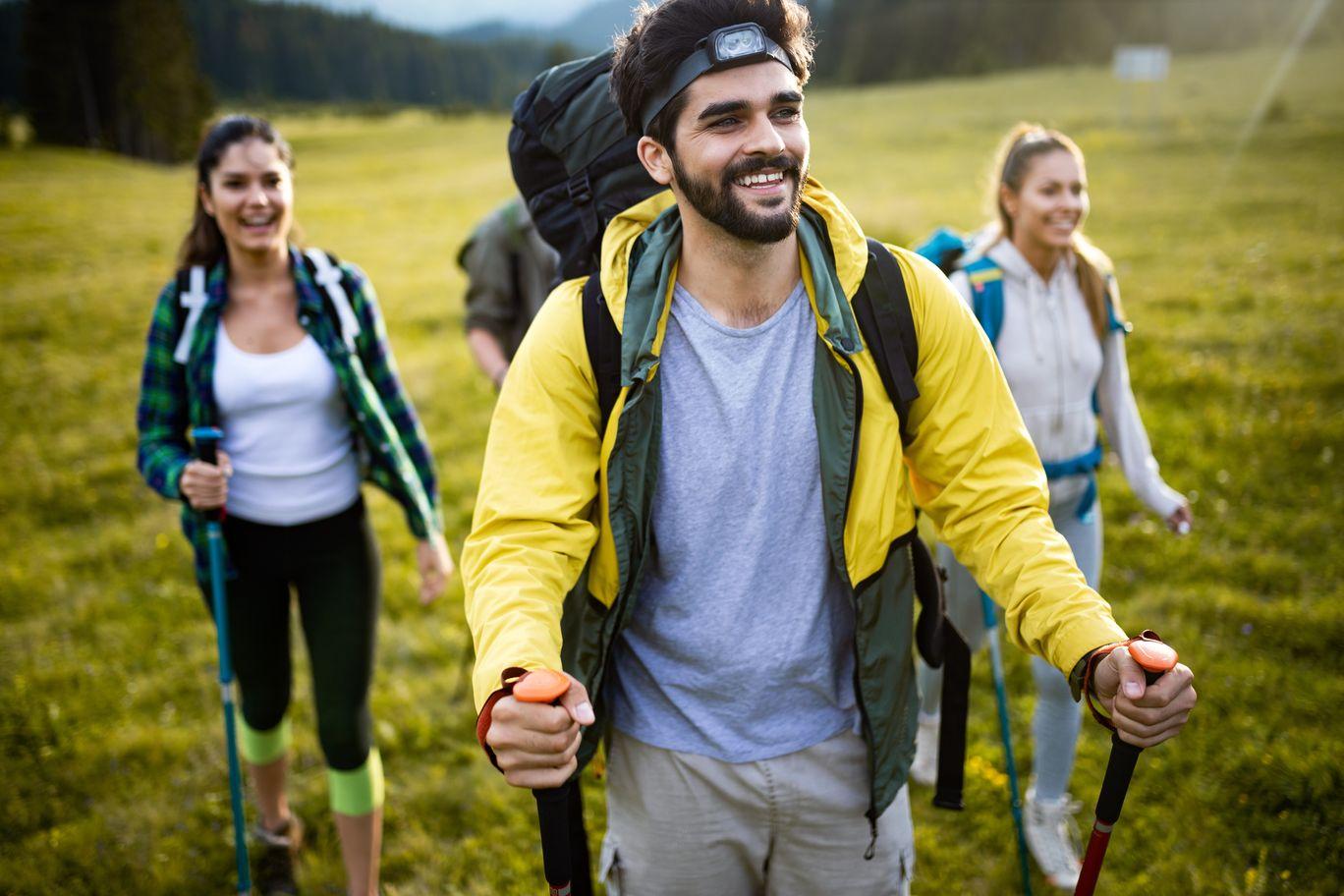 group-of-hikers-walking-on-a-mountain-and-smiling-A8QM735 - TAHAN Outdoor